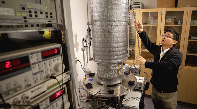 Linxiao Zhu shows the experimental platform that housed the calorimeter and photodiode. This platform damps vibrations from the room and building, steadily holding the two nanoscale objects 55 nanometers (0.000055 mm) apart.
