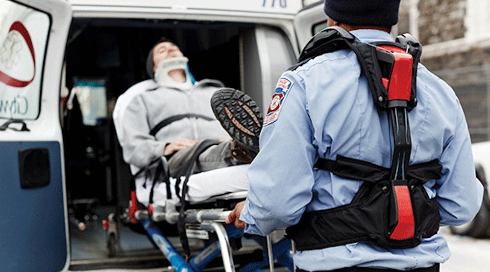 A paramedic uses the help from Strong Arm technologies V-22 passive exoskeleton vest to reduce injuries while lifting a patient into the ambulance.