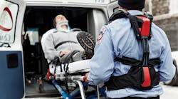 A paramedic uses the help from Strong Arm technologies V-22 passive exoskeleton vest to reduce injuries while lifting a patient into the ambulance.