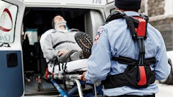 A paramedic uses the help from Strong Arm technologies V22 passive exoskeleton vest to reduce injuries while lifting a patient into the ambulance A paramedic uses the help from Strong Arm technologies V22 passive exoskeleton vest to reduce injuries while lifting a patient into the ambulance