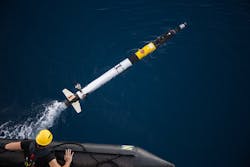 A team member launches an Iver autonomous underwater vehicle AUV On the rear is the transceiver fins and thruster A team member launches an Iver autonomous underwater vehicle AUV On the rear is the transceiver fins and thruster