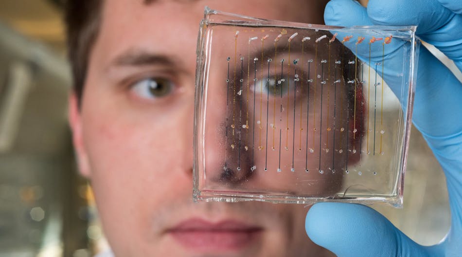 James Dahlman, an assistant professor at Georgia Tech and Emory University, holds a microfluidic chip used to fabricate nanoparticles that could be used to deliver therapeutic genes.