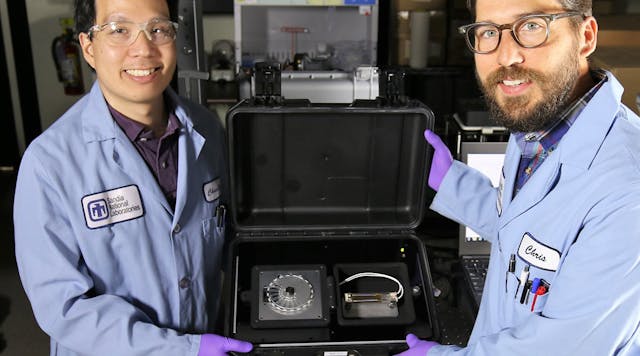 Sandia National Laboratories chemist Chung-Yan Koh, left, and former Sandia bioengineer Chris Phaneuf, right, hold the newly updated SpinDx diagnostic device.