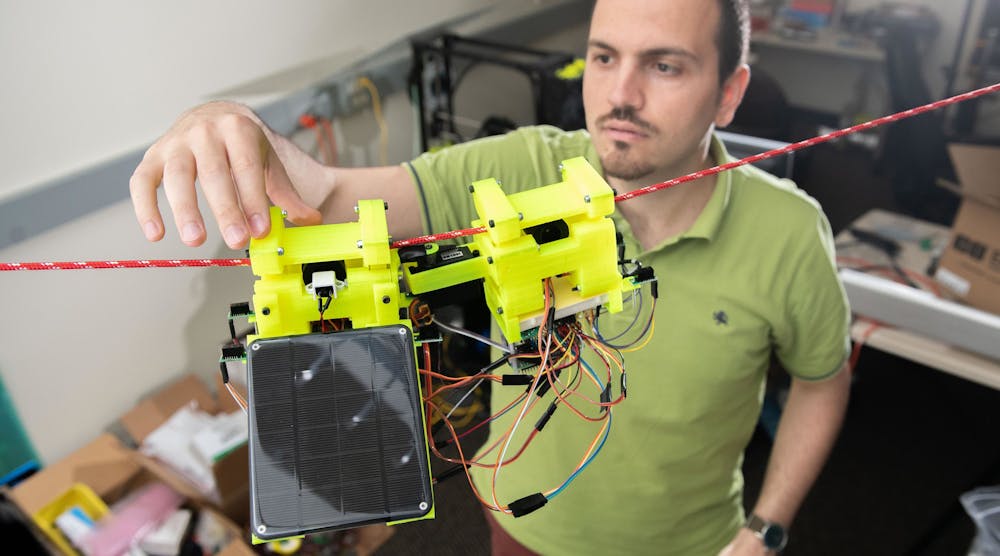 Graduate Research Assistant Gennaro Notomista shows the components of SlothBot on a cable in a Georgia Tech lab. The robot is designed to be slow and energy efficient for applications such as environmental monitoring.