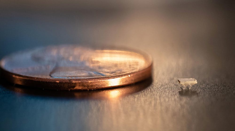 A micro-bristle-bot is shown next to a U.S. penny for size comparison.