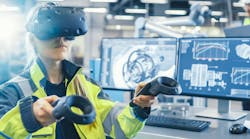 An engineer wearing VR goggles sees and manipulates information see sees attached to equipment with the paddles as she works on the factory floor.