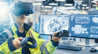 An engineer wearing VR goggles sees and manipulates information see sees attached to equipment with the paddles as she works on the factory floor.