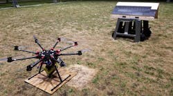 The roofing octocopter, equipped with a nailgun, is parked near the test roof. Setting the wooden panel at different inclines let researchers simulate roofs with different slopes.