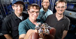 Sandia National Laboratories researchers (left to right: Nathan Harry, Christopher Nilsen, Drummond Biles, and Charles Mueller) show off their prototype of ducted fuel injection module for diesel engines.