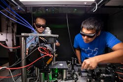 Researchers Satcher Hsieh (left) and Chong Zu tune the laser of their imaging system. When excited by laser light nitrogen vacancy centers emit photons, and their brightness tells researchers something about the local environment they are sensing.