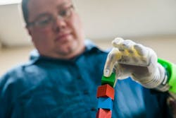 Joe Hamilton, a participant in the U-M RPNI study, naturally uses his mind to control a DEKA prosthetic hand to pick up a small block.