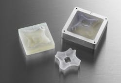 3D-printed injection molds in an aluminum frame with the finished injection molded part.