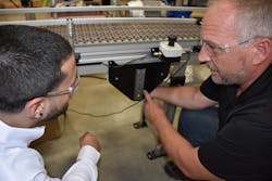 A seasoned engineer points out the accessories that were added to this Pointing out accessories on a plastic chain conveyor. A seasoned engineer points out the accessories that were added to this Pointing out accessories on a plastic chain conveyor.