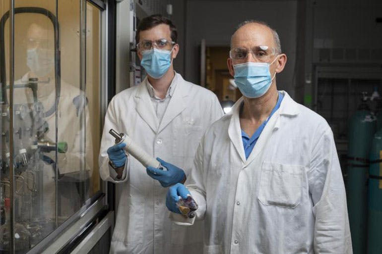 Georgia Tech Associate Professor Ryan Lively shows a module containing the new membrane material which could reduce refine oil while creating fewer carbon emissions and using less energy, while Professor M.G. Finn holds vials containing some of the other polymers used in this study.