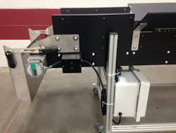 A stainless-steel chute can be attached to the end of the Hybrid conveyor. Technicians can adjust the width of a gap in the chute to let smaller objects fall through and be filtered out of the production stream and recycled into raw materials. In blow molding, the parts being filtered out are the tips and tails, the extra plastic from the tops and bottoms of the bottles. A stainless-steel chute can be attached to the end of the Hybrid conveyor. Technicians can adjust the width of a gap in the chute to let smaller objects fall through and be filtered out of the production stream and recycled into raw materials. In blow molding, the parts being filtered out are the tips and tails, the extra plastic from the tops and bottoms of the bottles.