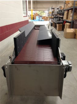 The Hybrid conveyor has its nylon coated sidewalls folded in to reduce its width. This makes it easier to install inside blow-molding machines. The Hybrid conveyor has its nylon coated sidewalls folded in to reduce its width. This makes it easier to install inside blow-molding machines.