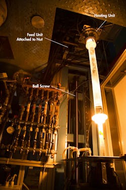 Ball screws drive deliver silicon preforms to heaters for melting, dripping and eventually hardening into a fine filament that is pulled onto a take-up spool. Ball screws drive deliver silicon preforms to heaters for melting, dripping and eventually hardening into a fine filament that is pulled onto a take-up spool.