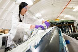 NREL researcher Robynne Murray works on a thermoplastic composite turbine blade at the NREL. Thermoplastics, unlike thermosets, can be recycled, which would make wind energy more sustainable while also lowering costs.