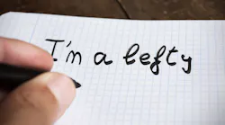 Closeup of a hand writing 'I'm a lefty'