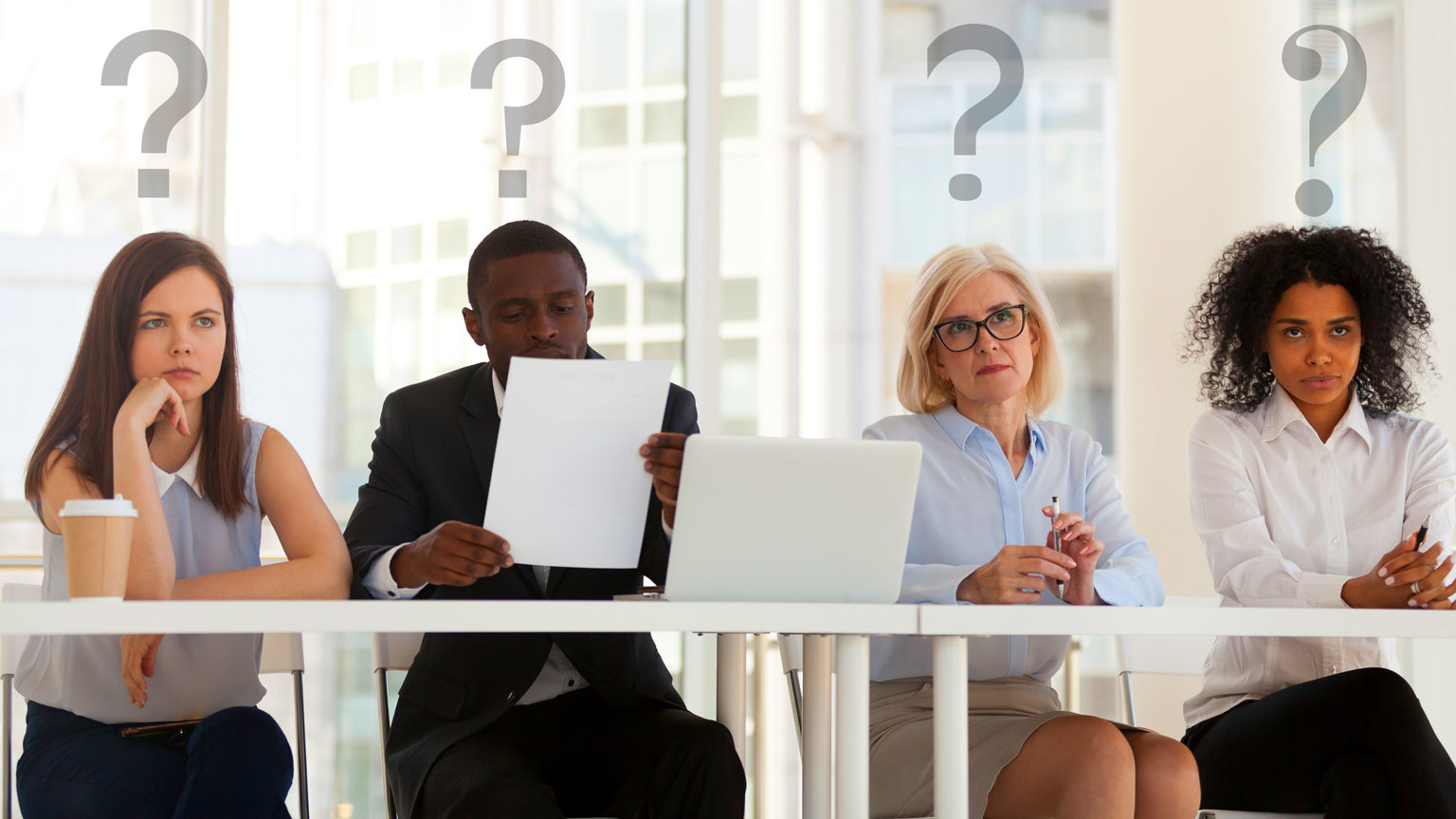 A table of people pondering a question