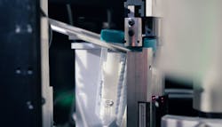 A test tube is positioned for having its cap removed. Several COVID-19 test swaps are in the tube, part of pool-processing approach. A test tube is positioned for having its cap removed. Several COVID-19 test swaps are in the tube, part of pool-processing approach.