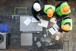 Workers looking over documents at a worksite Workers looking over documents at a worksite
