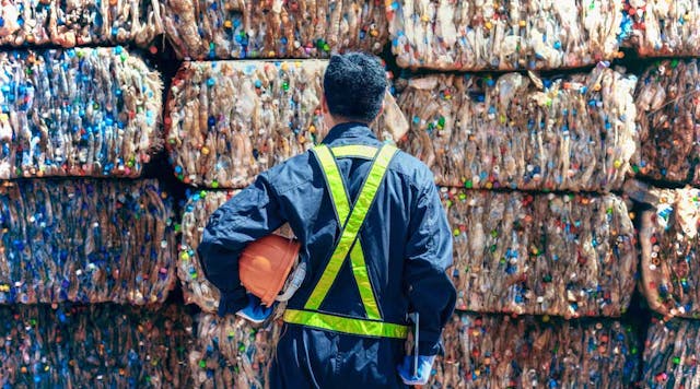 Worker standing in front of plastic waste bales
