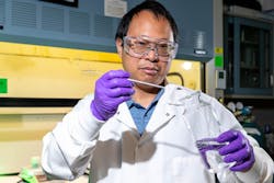 Sandia National Laboratory researcher Guangping Xu adds coal ash to a citric acid mixture. This solution will be fed into a reactor operating at about 70 times atmospheric pressure. In it, supercritical carbon dioxide uses citric acid to extract rare-earth metals.
