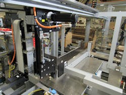 This cantilevered Y and Z axes system, center, pushes product into the wraparound case at the end of the slot.