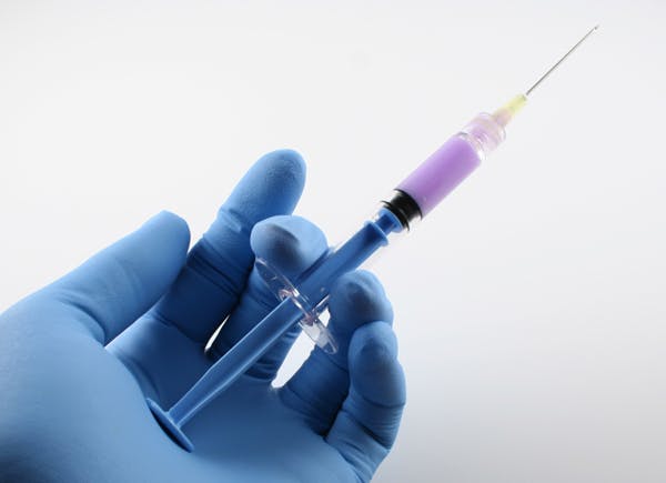 Hand holding syringe: Dry lubricating parts typically reduces actuation forces by 25-30%.