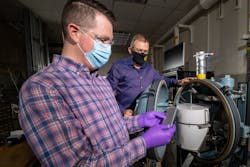 Alex Bates (front) and John Hewson, Sandia National Laboratories engineers, examine a lithium-ion battery in front of a specially designed battery testing chamber. Alex Bates (front) and John Hewson, Sandia National Laboratories engineers, examine a lithium-ion battery in front of a specially designed battery testing chamber.