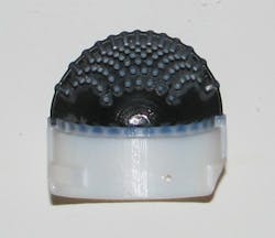 Cut-through section on the 3D-printed tactile skin. The white plastic is a rigid mount for the flexible black rubber skin. Both parts are made together on an advanced 3D-printer. The “pins” on the inside of the skin replicate dermal papillae that are formed inside human skin. Cut-through section on the 3D-printed tactile skin. The white plastic is a rigid mount for the flexible black rubber skin. Both parts are made together on an advanced 3D-printer. The “pins” on the inside of the skin replicate dermal papillae that are formed inside human skin.