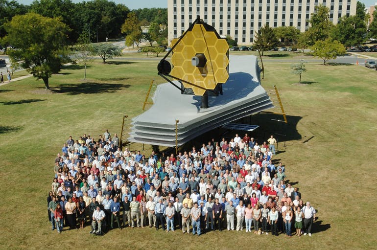 A full-scale model of the James Webb Space Telescope was assembled on the lawn at Goddard Space Flight Center. This photo gives a good indication of its size as some of the NASA personnel who designed and built it pose with it.