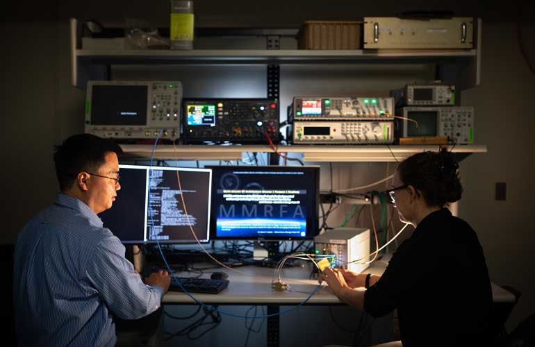 Sandia National Laboratories principal investigator Jacques Loui, left, and a firmware developer work at redesigning high-performance digital radar as a flexible, multipurpose sensor.