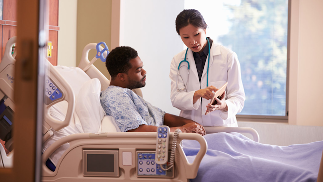 Patient in hospital bed talking with doctor