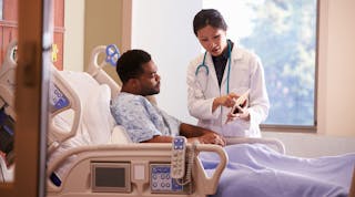 Patient in hospital bed talking with doctor