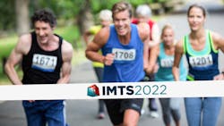 Runners approaching finish line with IMTS banner Runners approaching finish line with IMTS banner