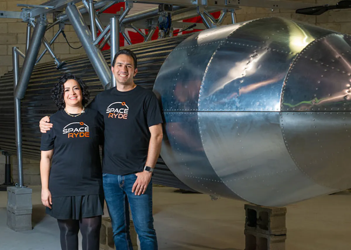 Saharnaz Safari and Sohrab Haghighat stand beside SpaceRyde balloon-carrier hardware