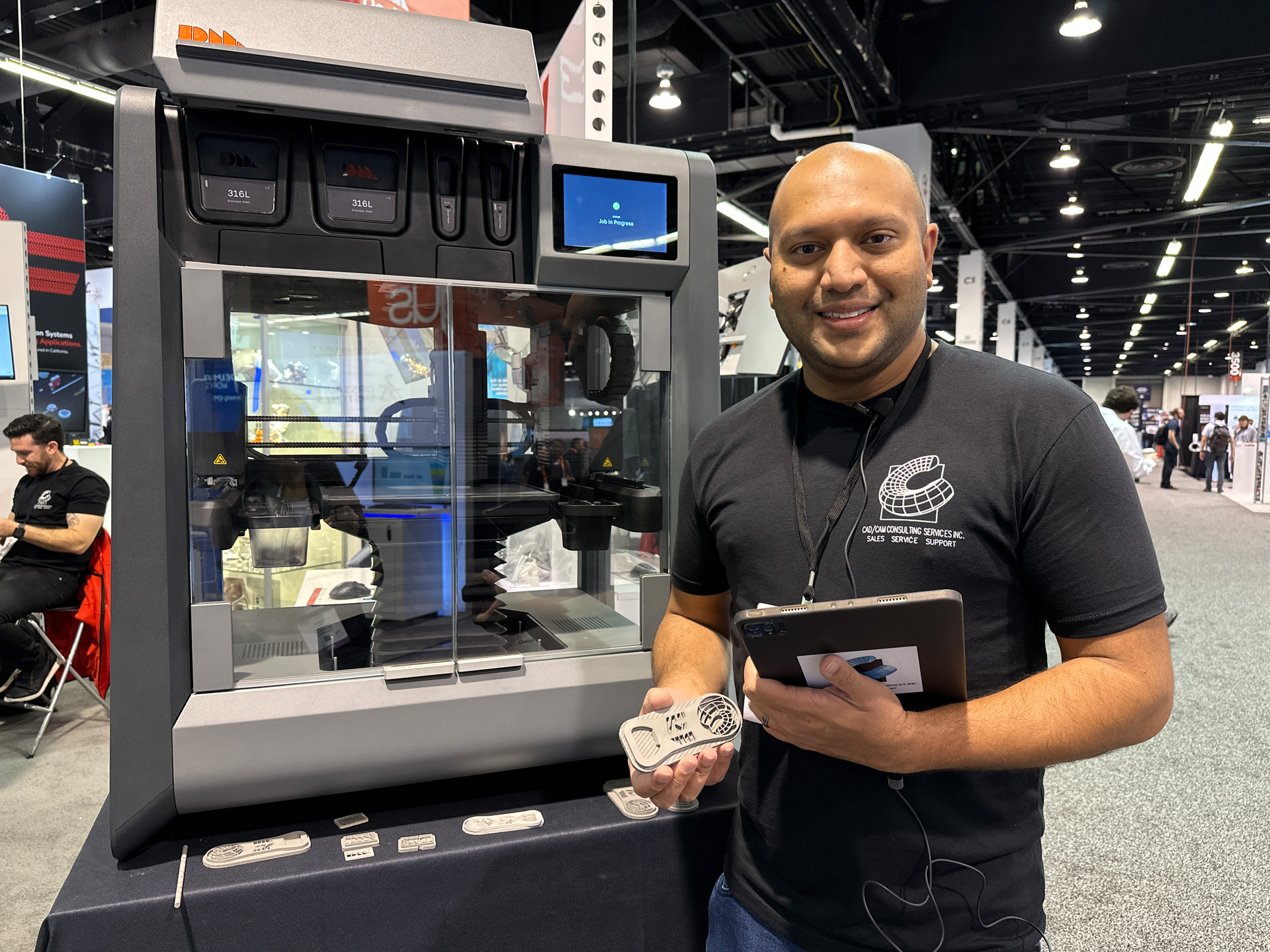 Axel Fernandes, additive manufacturing solutions lead with CAD/CAM Consulting Services, demonstrates the relationship between software, a Desktop Metal Studio 3D printer and the part he holds in his hand.