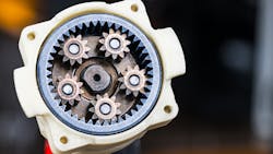 Metal cog wheels in open planetary gearbox of power drill on dark background Metal cog wheels in open planetary gearbox of power drill on dark background