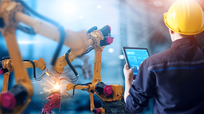 Engineer controls robotic arms welding