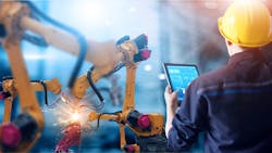 Engineer controls robotic arms welding Engineer controls robotic arms welding