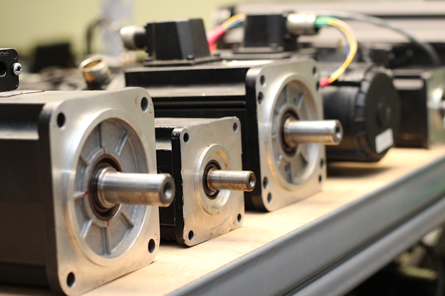 A shelf of servo motors representing various manufacturers, such as Allen Bradley, Rexroth, Siemens, Mitsubishi, Parker and Baldor. Providing power and precision, servo motors are the controlling force behind the equipment they run.