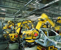 Robots welding cars in a production line.