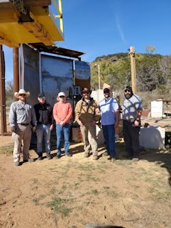 The metal sheet wall behind Dr. John Granier and his colleagues is a stationary fragmenting warhead test. High speed video records the time of arrival and pattern as fragments penetrate the metal wall. The metal sheet wall behind Dr. John Granier and his colleagues is a stationary fragmenting warhead test. High speed video records the time of arrival and pattern as fragments penetrate the metal wall.