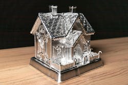 To create a detailed pattern on the gingerbread house’s roof, a three-axis machine was used to lay out the design before switching to a more complex five-axis machine, which permitted a tilted chimney to be added. To create a detailed pattern on the gingerbread house’s roof, a three-axis machine was used to lay out the design before switching to a more complex five-axis machine, which permitted a tilted chimney to be added.