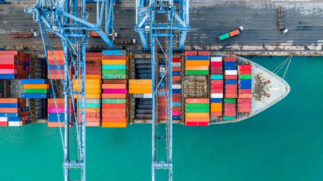 Aerial top view of a crane and shipping container