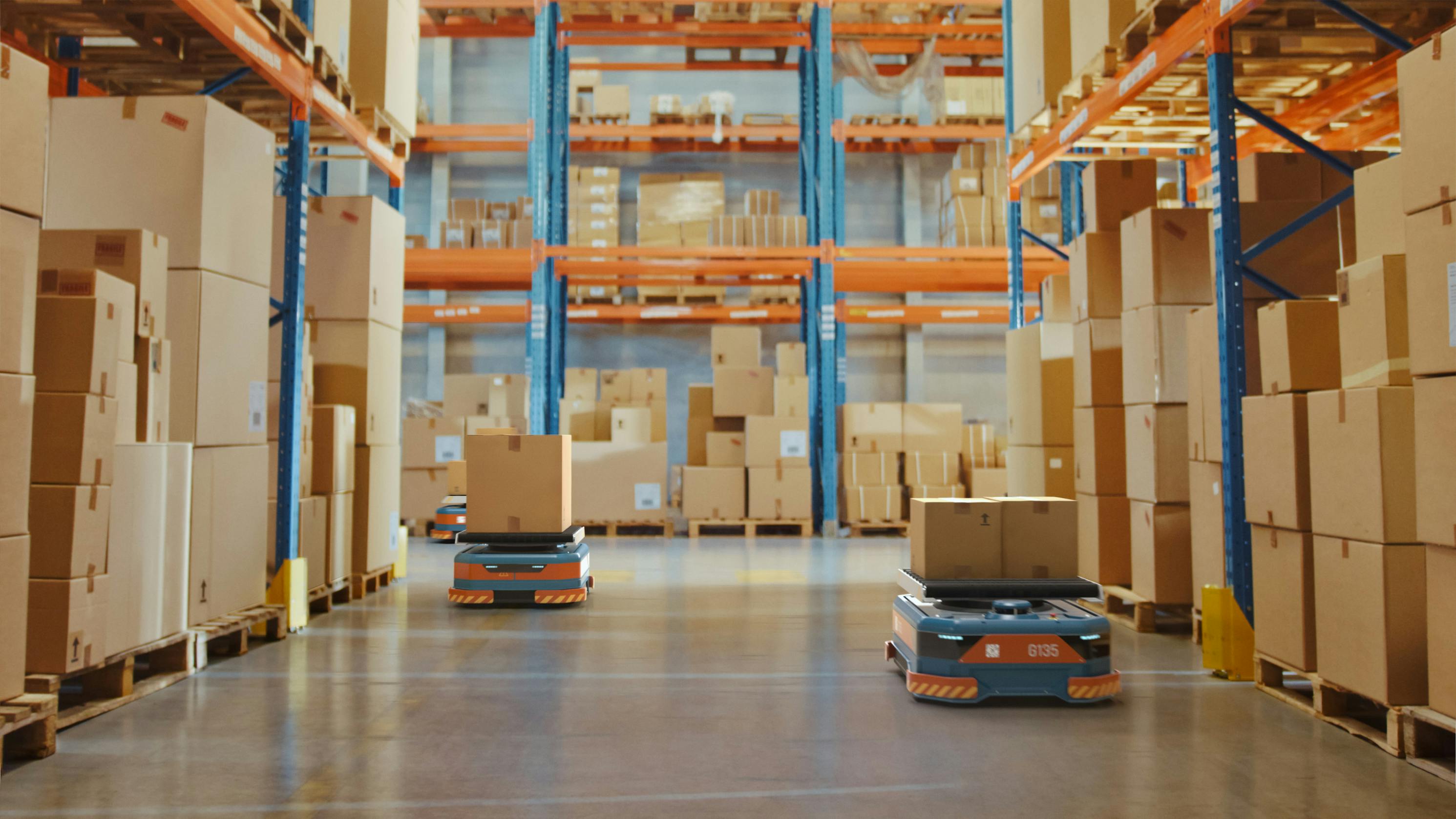 AGV Robots transporting cardboard Boxes in distribution logistics center.