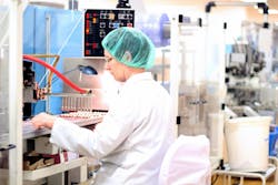 Robotic arm lifting ampoules at packaging line in pharmaceutical factory. Robotic arm lifting ampoules at packaging line in pharmaceutical factory.
