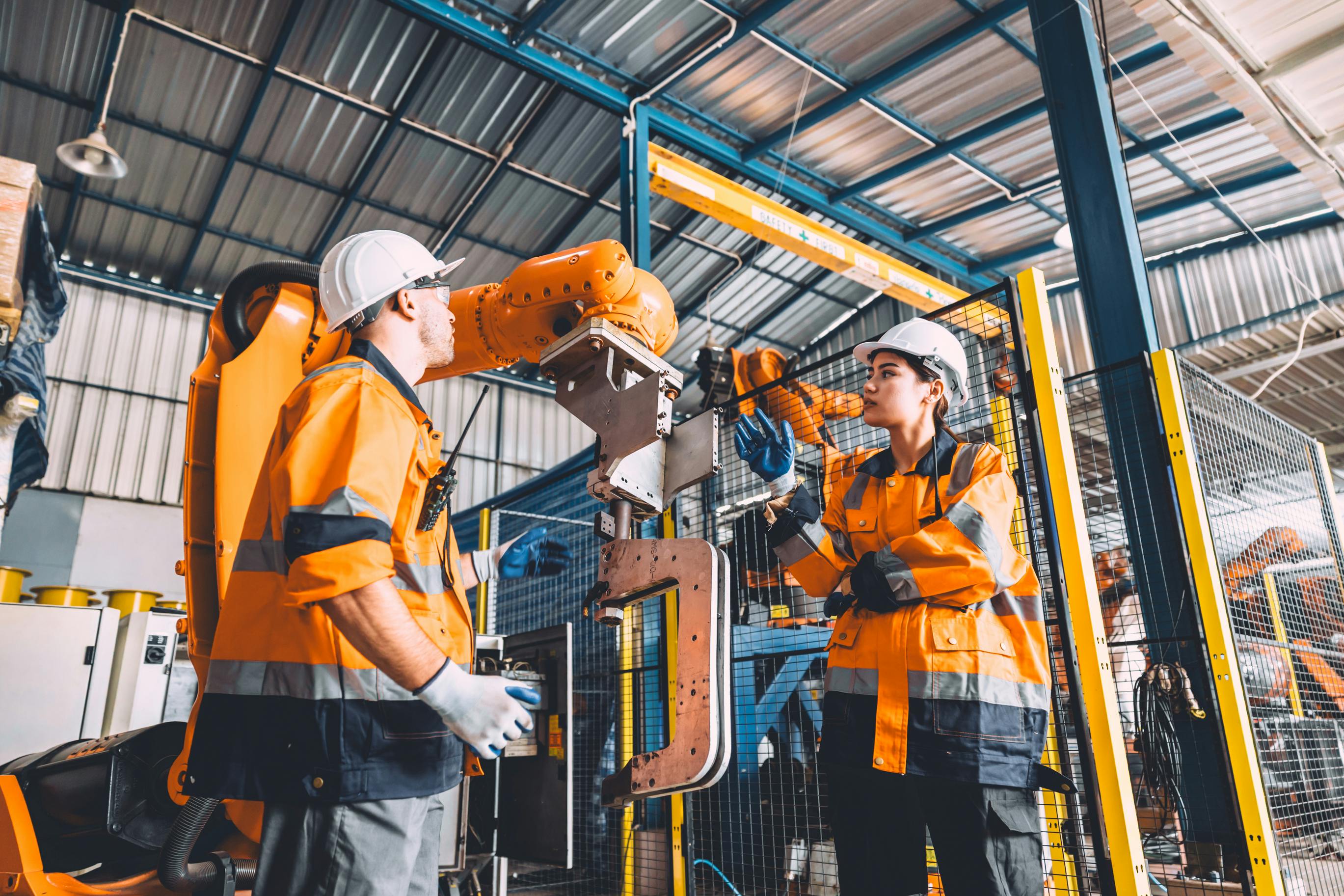 Workers and robot working side-by-side.
